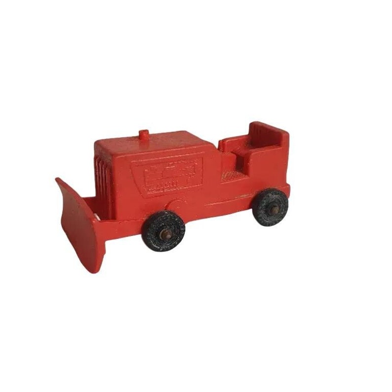 Puede incluir: Un bulldozer de juguete rojo con ruedas negras y una pala de pl&aacute;stico negra. El bulldozer tiene una peque&ntilde;a cabina con un asiento y un volante de pl&aacute;stico negro.