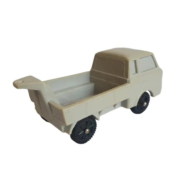 May include: A gray toy truck with a flatbed and a cab. The truck has black wheels and a white interior.