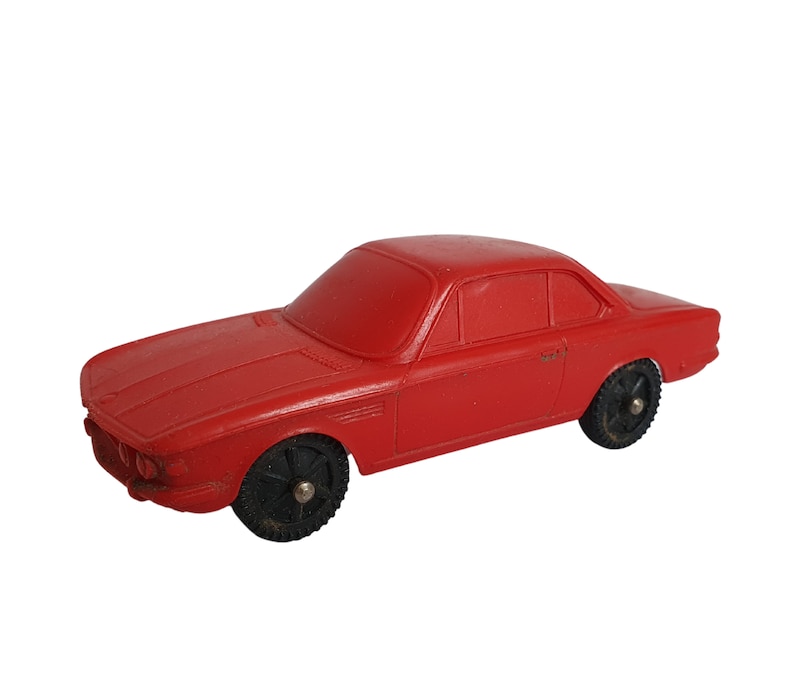May include: A red toy car with black wheels. The car has a detailed design and is made of plastic.