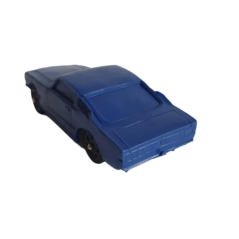 May include: A dark blue toy car with black wheels. The classic car has a sleek design with a sloped roof and a detailed rear end. The toy car is a miniature replica of a vintage vehicle.