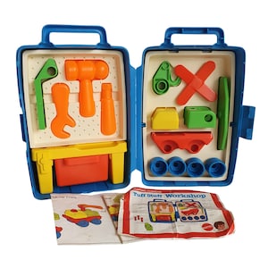 May include: A blue plastic toolbox toy with a variety of colorful plastic tools and building blocks. The toolbox has a handle and opens to reveal the tools and blocks inside. The box has the words "Tuff Stuff Workshop" printed on the front.