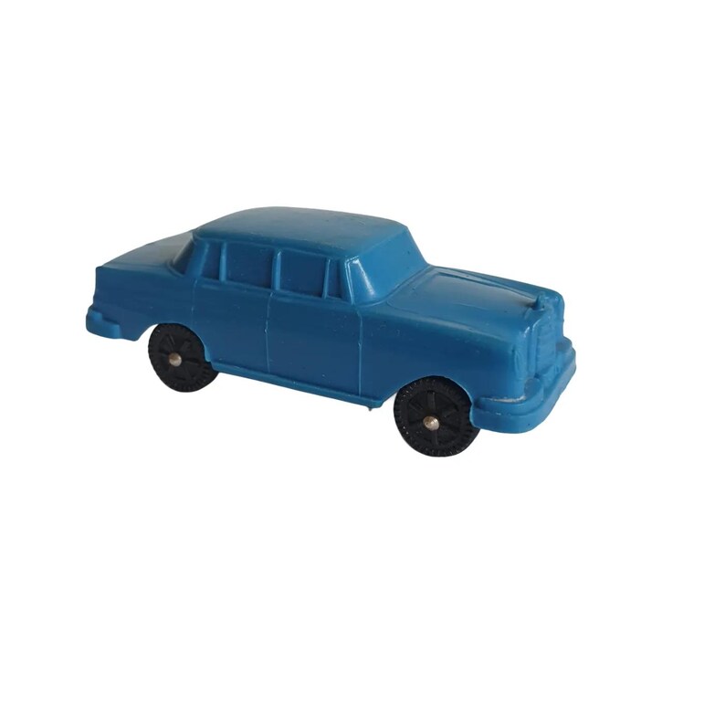Puede incluir: Un coche de juguete azul con ruedas negras. El sed&aacute;n cl&aacute;sico tiene una parrilla delantera detallada y cuatro ventanas laterales. El coche de juguete est&aacute; hecho de pl&aacute;stico y sobre un fondo blanco.