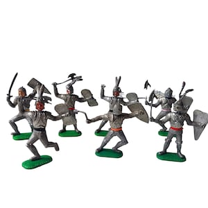 May include: A set of six silver toy knights with swords, shields, and axes. The knights are standing on green bases and are ready for battle.