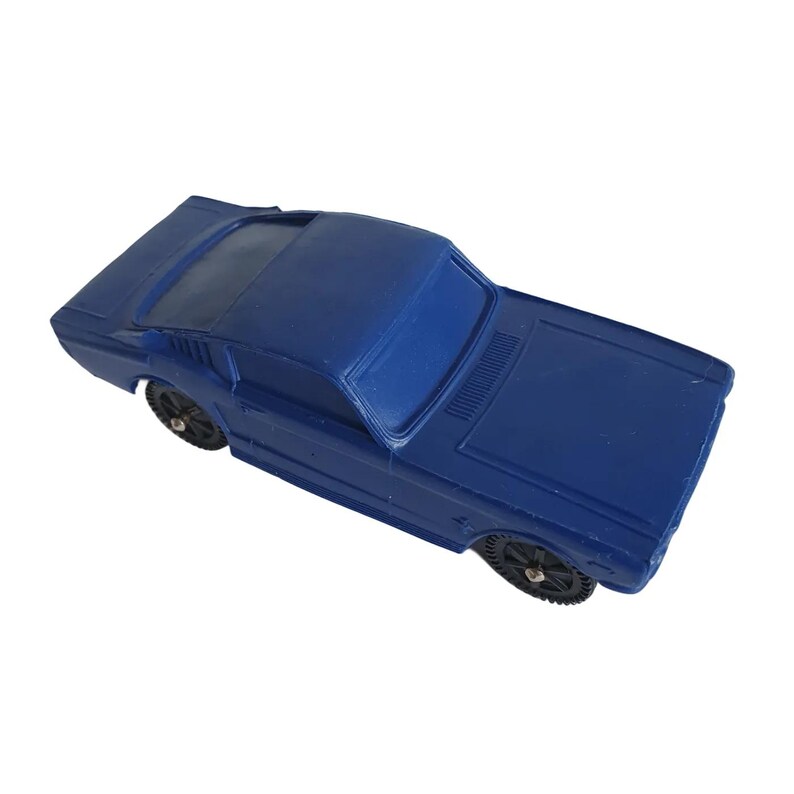 May include: A solid blue toy car with black wheels. The classic car has a sleek design, featuring a low profile and a detailed front end. The toy car is a miniature replica of a vintage model.