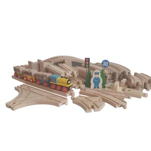 May include: A wooden toy train set with a yellow engine, multiple cars, and a wooden track with a bridge, a traffic light, and a sign that says "30".