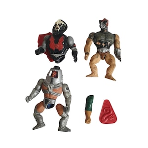Op de afbeelding: Vier vintage actiefiguren. Eén figuur heeft een zwart en rood borststuk en een rode cape. Een andere figuur is bruin en grijs met een zilveren arm. De derde figuur is zilver en oranje. Er is ook een groene en bruine poot en een rood slangvormig stuk.