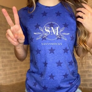 May include: A blue t-shirt with a white star pattern and a white logo that says "SM SAVVYMOCKS" in a circle.