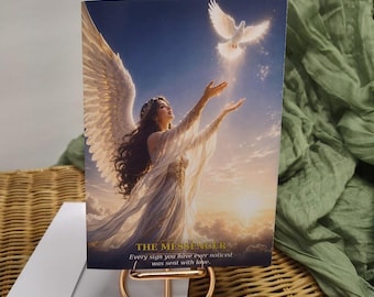 May include: A rectangular greeting card titled THE MESSENGER featuring an illustration of an angel with long dark hair and large white wings reaching toward a white dove in a golden sunset sky. The text reads: Every sign you have ever noticed was sent with love.