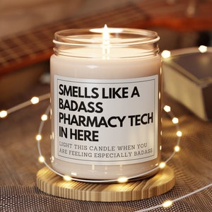 May include: A white candle with a black label that reads "Smells like a badass pharmacy tech in here. Light this candle when you are feeling especially badass."