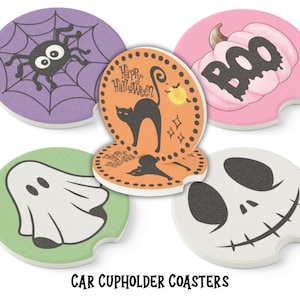 May include: Set of five Halloween-themed car cup holder coasters. Designs include a spider and web, a black cat, a pumpkin with the word "BOO", a ghost, and a skull. The text "CAR CUPHOLDER COASTERS" is at the bottom.