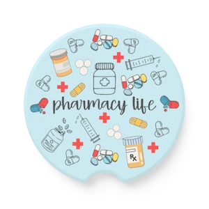 Könnte beinhalten: Ein hellblauer Auto-Untersetzer mit Apotheken-Motiv. Der Untersetzer zeigt Illustrationen von Pillen, Medikamentenflaschen, Spritzen und Verbänden. Die Worte "pharmacy life" sind in einer Schreibschrift geschrieben.