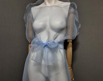 Vestido largo azul pálido con cinturón, confeccionado en organza arrugada transparente. Chaqueta transparente sin mangas con diseño reversible.