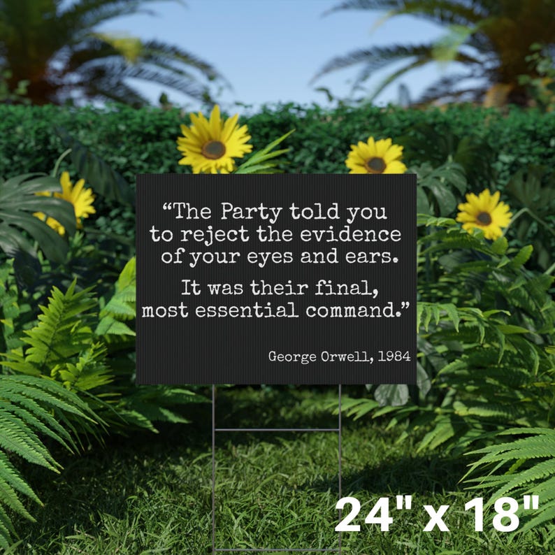 May include: A black rectangular yard sign featuring a quote from George Orwell's 1984: "The Party told you to reject the evidence of your eyes and ears. It was their final, most essential command." The sign is 61cm x 46cm and is in a garden.
