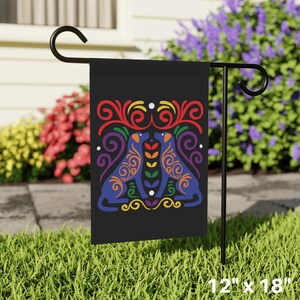 May include: A black garden flag with a rainbow-colored design of two dogs facing each other. The dogs are outlined in blue and have colorful swirls and patterns. The flag is 12 inches by 18 inches.