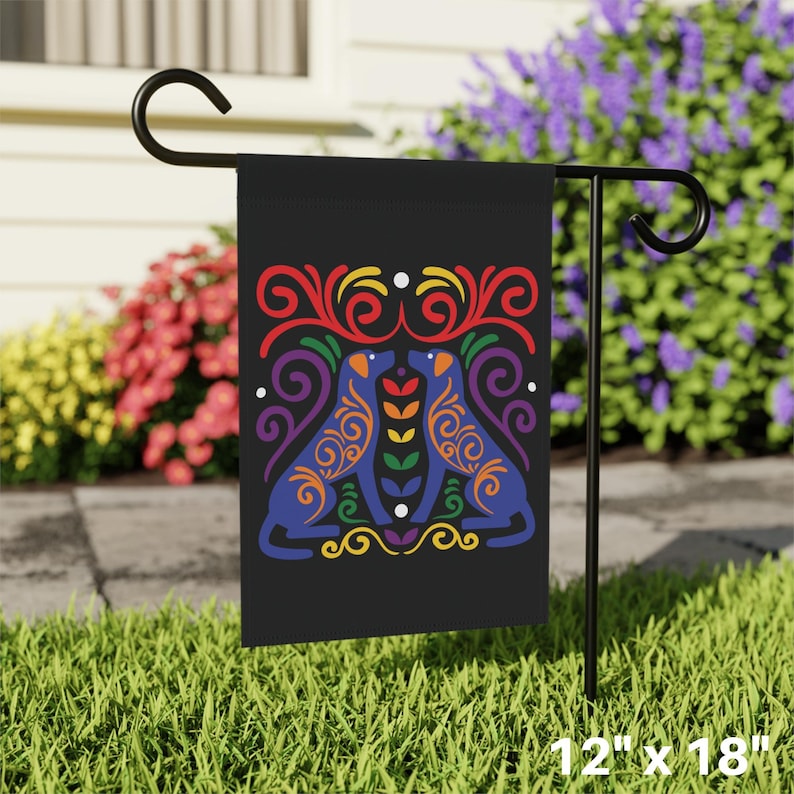 May include: A black garden flag with a rainbow-colored design of two dogs facing each other. The dogs are outlined in blue and have colorful swirls and patterns. The flag is 12 inches by 18 inches.