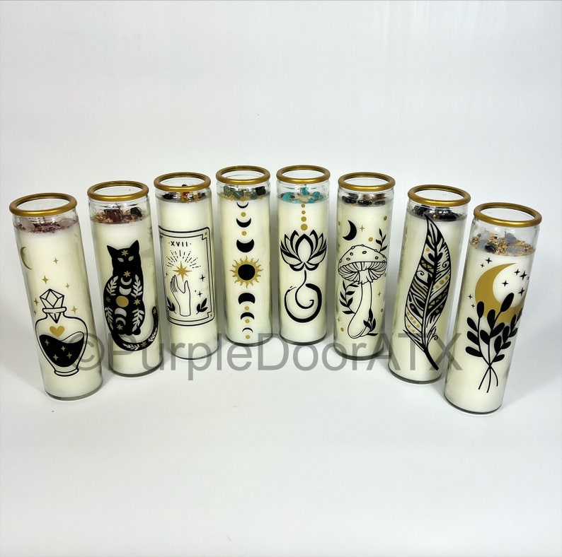 A set of eight glass candles with mystical designs on front and crystals on top.