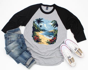 May include: A grey raglan shirt with black sleeves, featuring a beach scene graphic. The graphic shows a tropical beach with palm trees, ocean waves, and red flowers. Also includes blue jeans and white trainers.