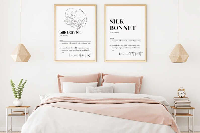 Puede incluir: Dos impresiones enmarcadas con ilustraciones en blanco y negro de un gorro de seda. El texto en las impresiones dice "Silk Bonnet" y define la palabra como un "promotor, ride-or-die, & guardi&aacute;n de tu cabello. Incluso cuando se desliza, desaparece milagrosamente por la noche, siempre te despertar&aacute;s a su lado. Cuidado del cabello del m&aacute;s alto nivel."