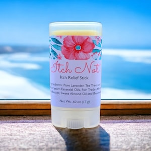 May include: A white and clear Itch Relief Stick with a floral design and the words "Itch Not". The stick contains .60 oz (17 g) of ingredients including lavender and tea tree essential oils. The background is a blurred view of the ocean.