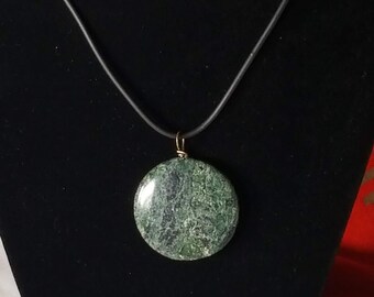 May include: A green stone pendant on a black cord necklace. The stone has a swirling pattern.