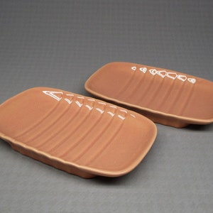May include: Two rectangular ceramic dishes with a light brown glaze and a ribbed design.