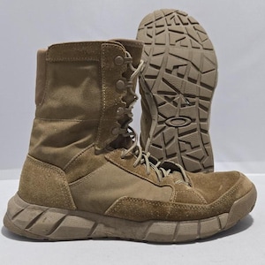 May include: Tan tactical boots with a robust sole and lace-up fastening. The boots combine canvas and suede, providing durability and a military look. The sole is designed for grip and stability. The boots are approximately 20 cm high.