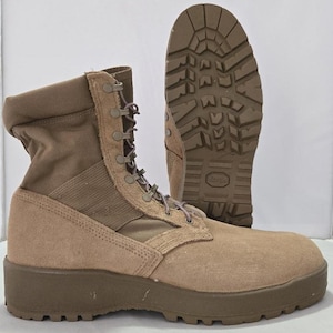 May include: Tan combat boots with a rugged sole and lace-up design. The boots have a suede-like texture on the lower portion and a canvas-like material on the upper shaft. One boot is upright, and the other is positioned to show the sole.