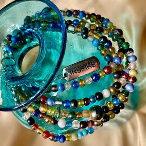 May include: Multicolored glass bead bracelet with a silver charm that says "INSPIRE".