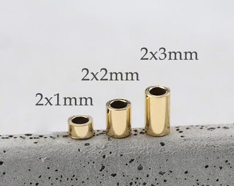May include: Three gold-colored metal tubes of different sizes, labeled 2x1mm, 2x2mm, and 2x3mm. The tubes are sitting on a gray textured surface.