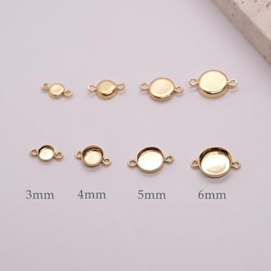 May include: Gold-coloured bezel settings in various sizes, ranging from 3mm to 6mm. Each setting has a circular design with loops on either side for attaching to other components. Ideal for jewellery making.