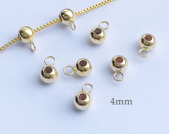May include: Gold-toned metal bead caps with a 4 mm diameter. The bead caps have a small loop on each side for attaching to jewelry.