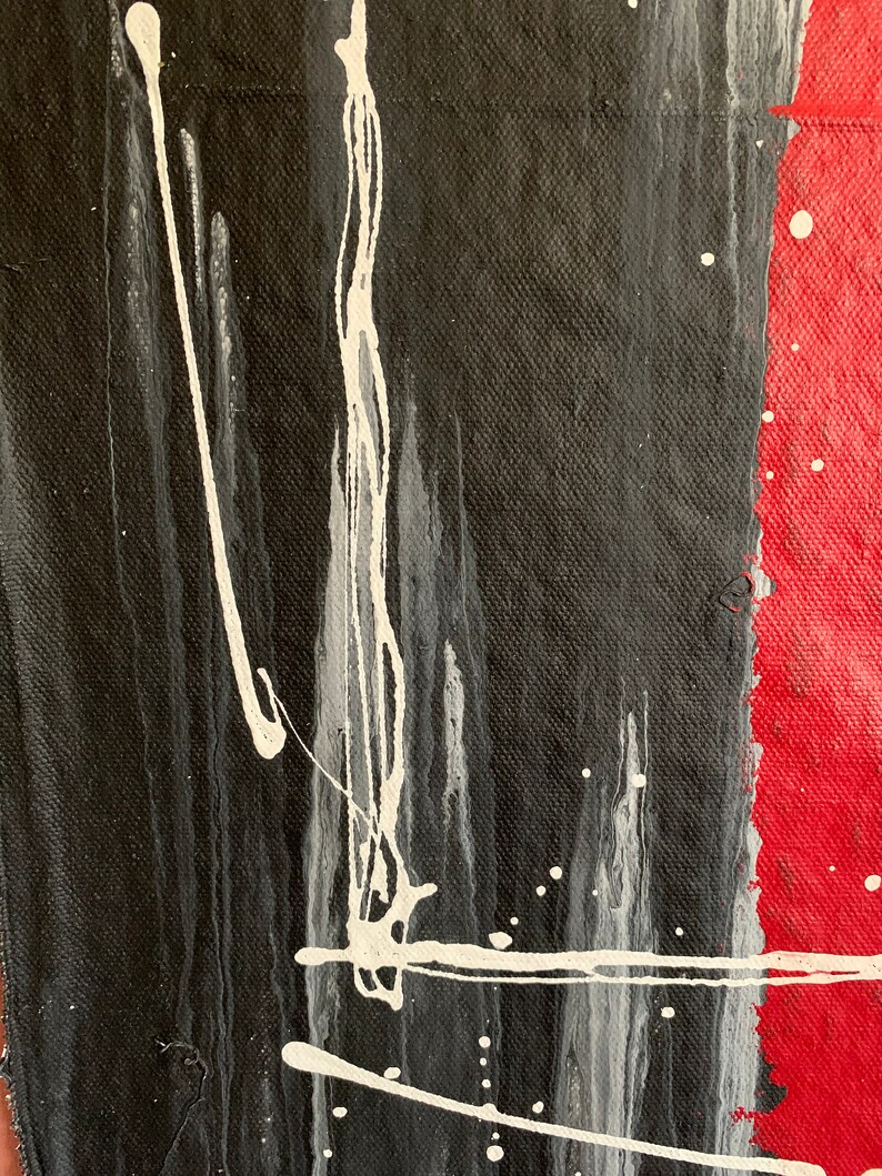 Puede incluir: Pintura abstracta con salpicaduras y rayas de pintura negra, blanca y roja sobre un lienzo.