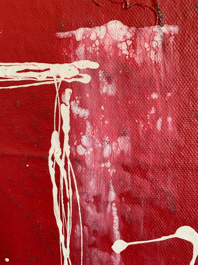 Puede incluir: Pintura abstracta con salpicaduras y goteos de pintura blanca sobre un fondo rojo. La pintura blanca crea un efecto texturizado.