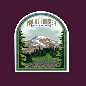May include: A vintage-style sticker featuring a scenic view of Mount Rainier National Park in Washington state. The sticker has a blue and green color scheme with a white border and text that reads "Mount Rainier National Park, Washington".