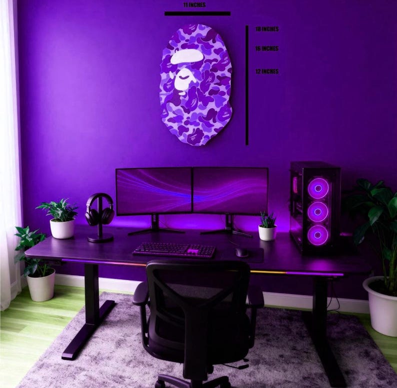 Puede incluir: Una configuraci&oacute;n de juego de color p&uacute;rpura con un escritorio, monitores duales, una torre de computadora y una silla negra. Una decoraci&oacute;n de pared con una cara de camuflaje p&uacute;rpura, 46 cm de alto y 28 cm de ancho. La habitaci&oacute;n est&aacute; iluminada con luces p&uacute;rpuras.