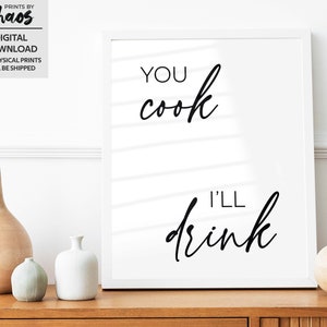 以下が含まれることがあります： 白い額縁に入ったプリント。黒い文字で「You cook I'll drink」と書いてあり、白いストライプの背景になっています。