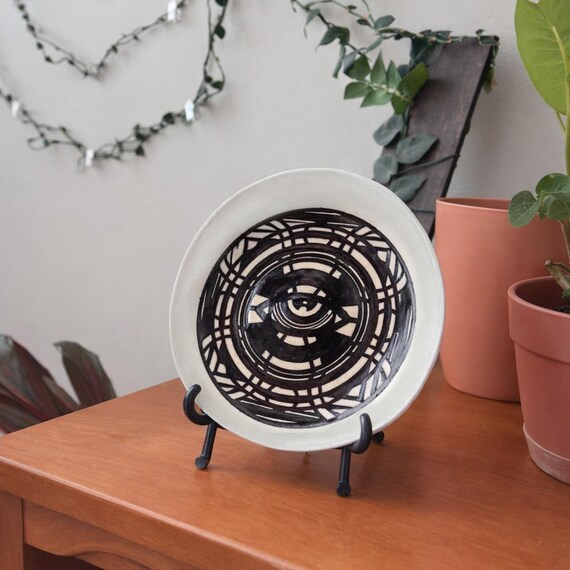 Hand-thrown ceramic dish with an evil eye motif — actual pottery with spiritual character, not a mass-printed pattern slapped on a blank.