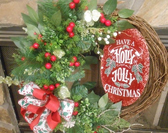 May include: A Christmas wreath with a red sign that says "Have a Holly Jolly Christmas". The wreath is decorated with green pine branches, red berries, and a red and white bow.