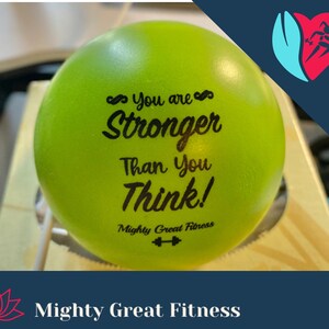 May include: A green exercise ball with the text "You are Stronger Than You Think! Mighty Great Fitness" printed on it.