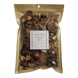 May include: A clear plastic bag filled with dried botanicals. The bag has a brown paper backing and a small white label with the text "Spiritual Kids Banana Nut Bread". The contents are various shades of brown and tan.