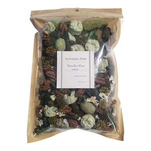 May include: A brown paper bag filled with a variety of dried potpourri. The bag has a label that reads "Spiritual Kids Mountain Pine Potpourri".