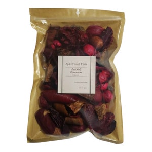 May include: A brown paper bag filled with potpourri. The potpourri is a mix of red, pink, and brown pieces. The bag has a label that says "Spiritual Kids Red Hot Cinnamon Potpourri".