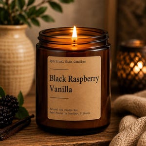 Może przedstawiać: Zapalona świeca w brązowym szklanym słoiku z beżową etykietą z napisem Spiritual Kids Candles Black Raspberry Vanilla Natural Soy Candle 227g Hand Poured in Bradley, Illinois. Świeca posiada jeden płonący knot z ciepłym blaskiem.