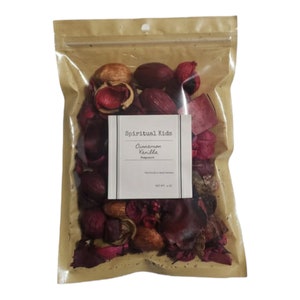 May include: A clear plastic bag filled with potpourri. The potpourri is a mix of dried flowers and other natural materials in shades of red, brown, and beige. The bag has a label that reads "Spiritual Kids Cinnamon Vanilla Fragrant".