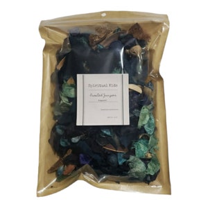 May include: A brown paper bag with a clear plastic window, filled with a mix of blue, green, and brown potpourri. The bag has a label that reads "Spiritual Ride, Frankincense Juniper, Fragrance".