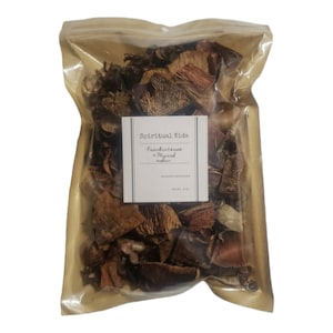 May include: A clear plastic bag filled with dried, reddish-brown botanicals. A white label reads "Spiritual Kids" with "Frankincense + Myrrh" below. The bag is sealed and contains a variety of textured, dried plant matter.