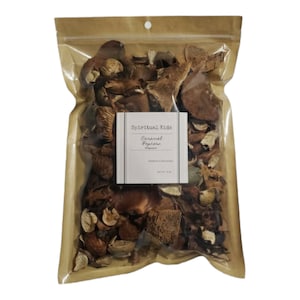 May include: A clear plastic bag filled with dried botanicals and a kraft paper top. A white label reads "Spiritual Kids" and "Caramel Popcorn". The contents are various shades of brown and beige. The bag is sealed with a small hole at the top.