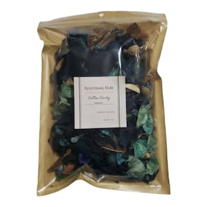 May include: A brown paper bag with a clear plastic window, containing a mix of potpourri in shades of blue, green, and brown. The bag has a label that reads "Spiritual Kids Cotton Candy Fragrance".