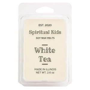 May include: A rectangular clear plastic clamshell package containing off-white soy wax melts. The label reads EST. 2020, Spiritual Kids, SOY WAX MELTS, White Tea, MADE IN ILLINOIS, and NET WT. 2.6 oz, printed in black text on a white background.