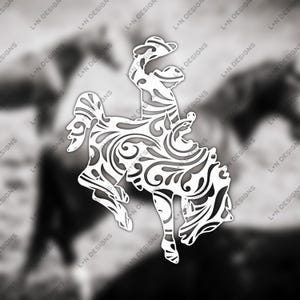 May include: White decorative silhouette of a bucking bronco and rider, featuring intricate floral and swirl patterns. The design is set against a blurred black and white background, with the text "L+N DESIGNS" repeated.